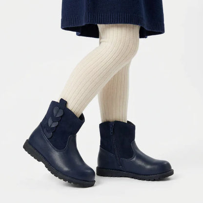 Bottines enfant bleu marine portées avec collants clairs, semelle antidérapante et détails en forme de cœur.